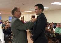 Lion John Lynde pins Lion Chris Norcross as new President