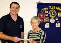 Lion Chris Norcross presents Jan Carlton with $1000 check for Western Wake Crisis Ministry