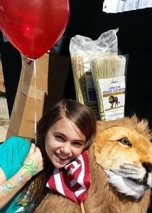Girl poses with stuffed lion at Peakfest 2016