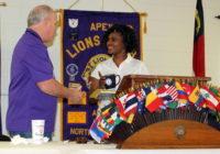 Lion Tony presents speaker Tomeico with a Lions Club mug