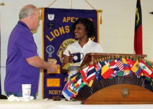 Lion Tony presents speaker Tomeico with a Lions Club mug