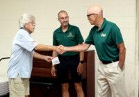 Lion Horace presents the check to Coach Gilles and Coach Roy
